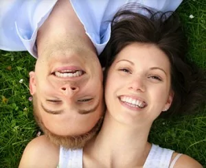 Couple lie on the ground after getting a tooth extraction in Shavano Park, as well as some other general dentistry treatments.