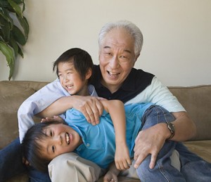 Grandfather playing with children shows off his all on 4 permanent dentures that he obtained in San Antonio.